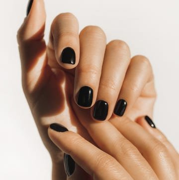 Manicure on female hands with black nail polish. manicure on female hands with black nail polish